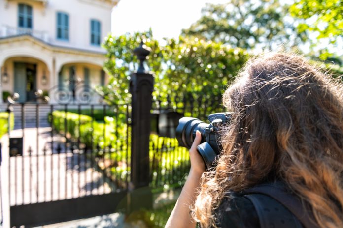 real estate photographer taking picture of house