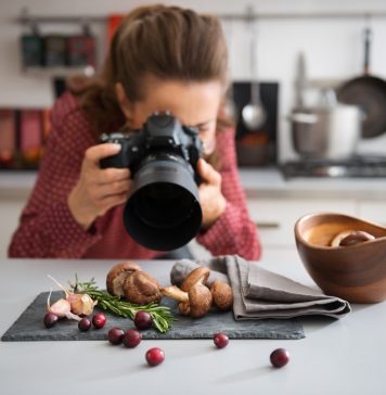 4 Food Photography Lenses You Need in Your Kit food photographer in a kitchen with fall fruits and vegetables