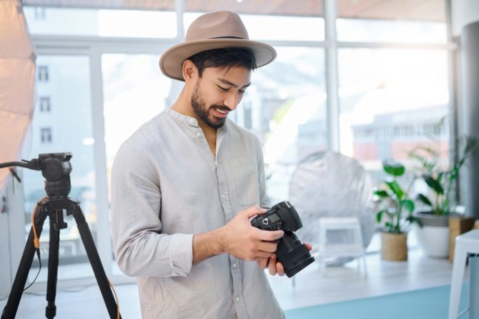 Photographer in his studio looking through images on a camera