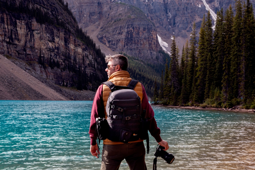 Photographer standing in front of a mountain lake