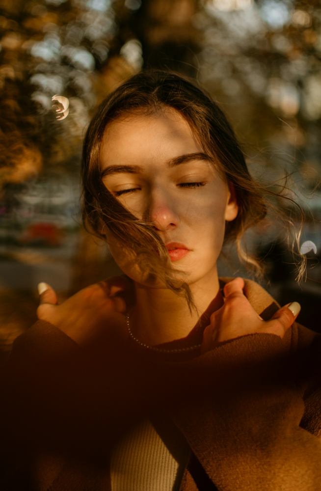 woman with her eyes closed holding her coat collar
