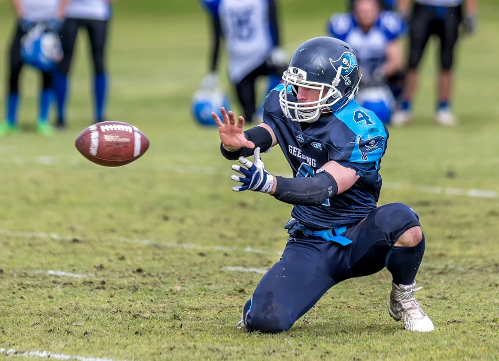 Football player about to catch a ball