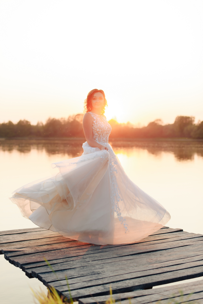 bride in white dress on wooden pier