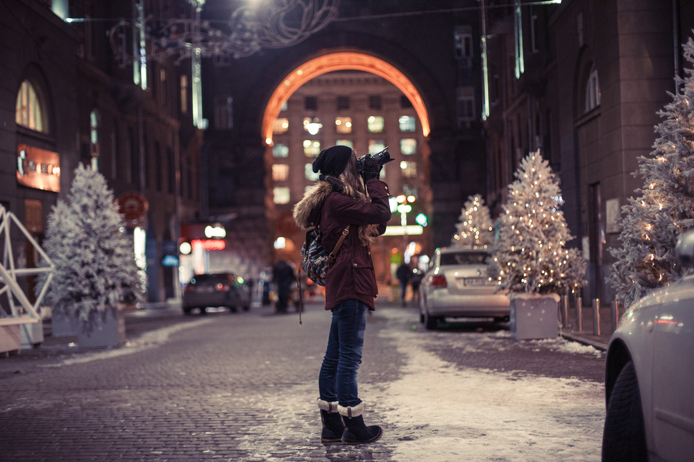 photographer taking photos of buildings and Christmas trees