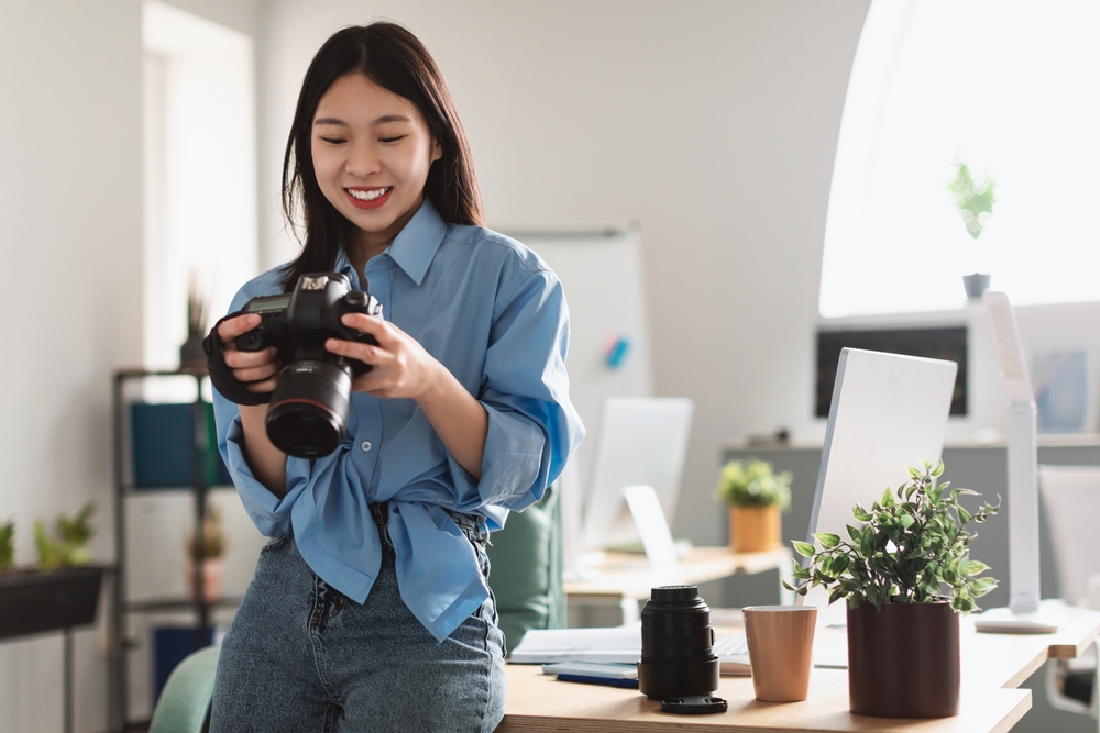 Photographer Holding Camera Looking Through Taken Pictures