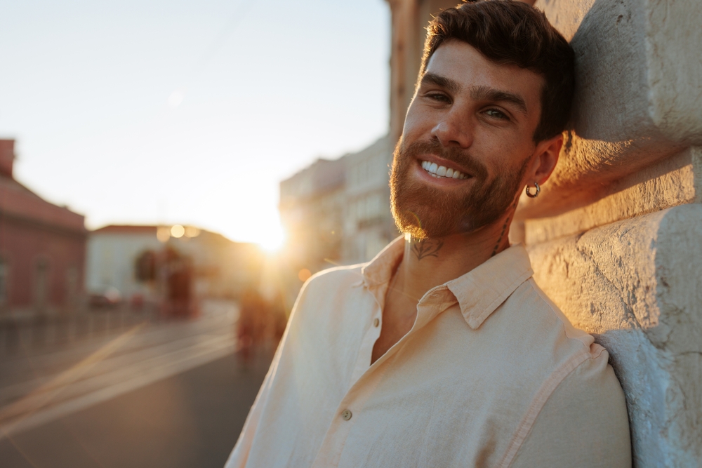 portrait of man at sunset leaning on a wall