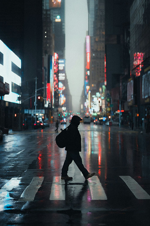 man crossing street at night