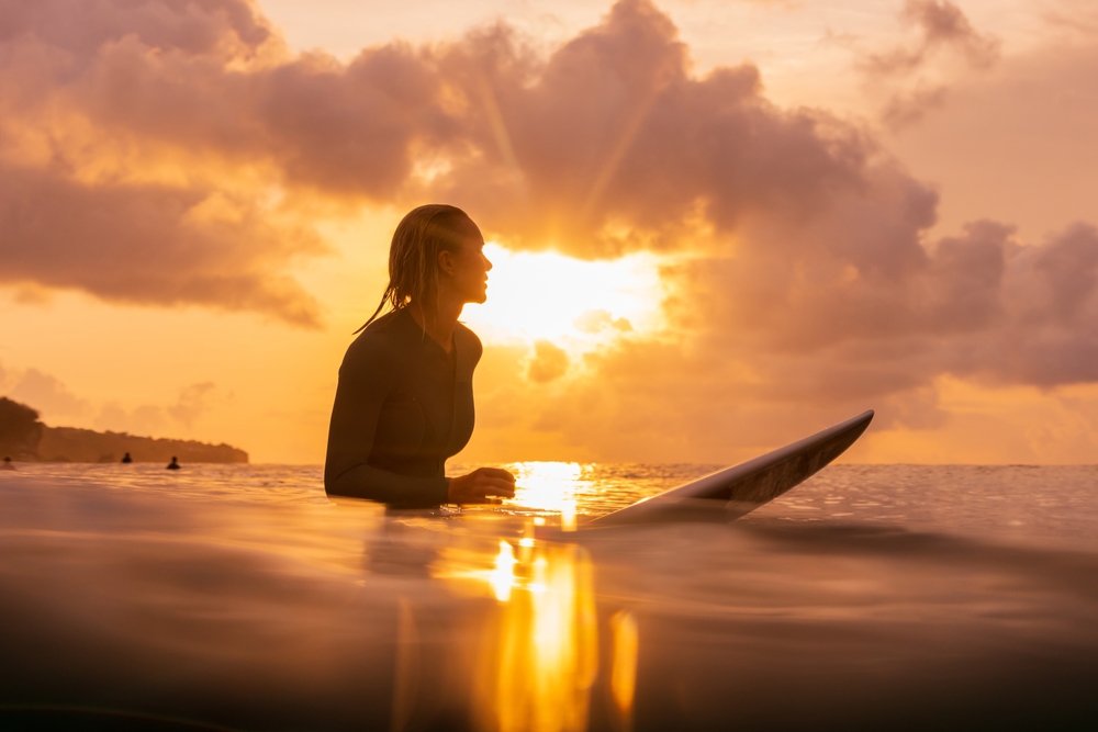 female surfer at sunset