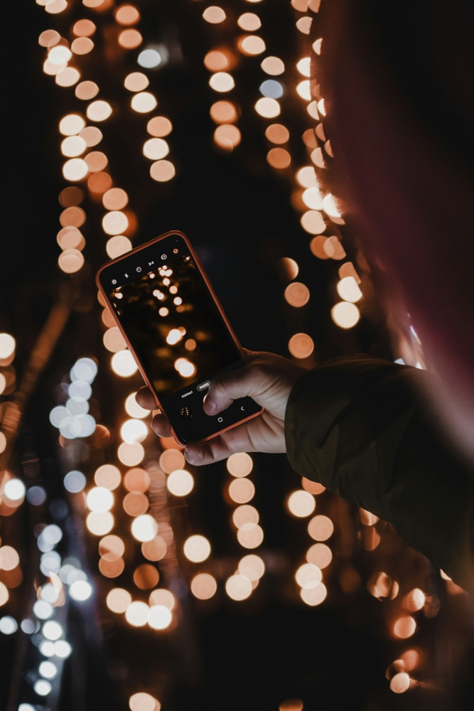 using a cell phone to take photos of Christmas lights