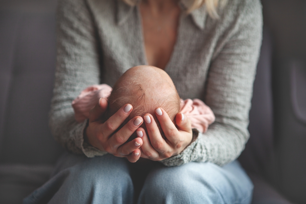 mom gently cradling and rocking newborn baby