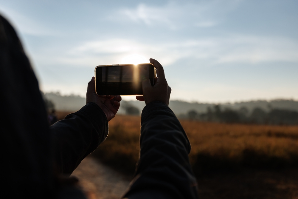 Person using a phone camera to take landscape photos