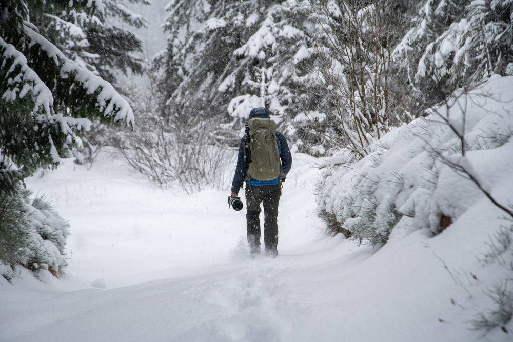 photographer hiking in the deep snow