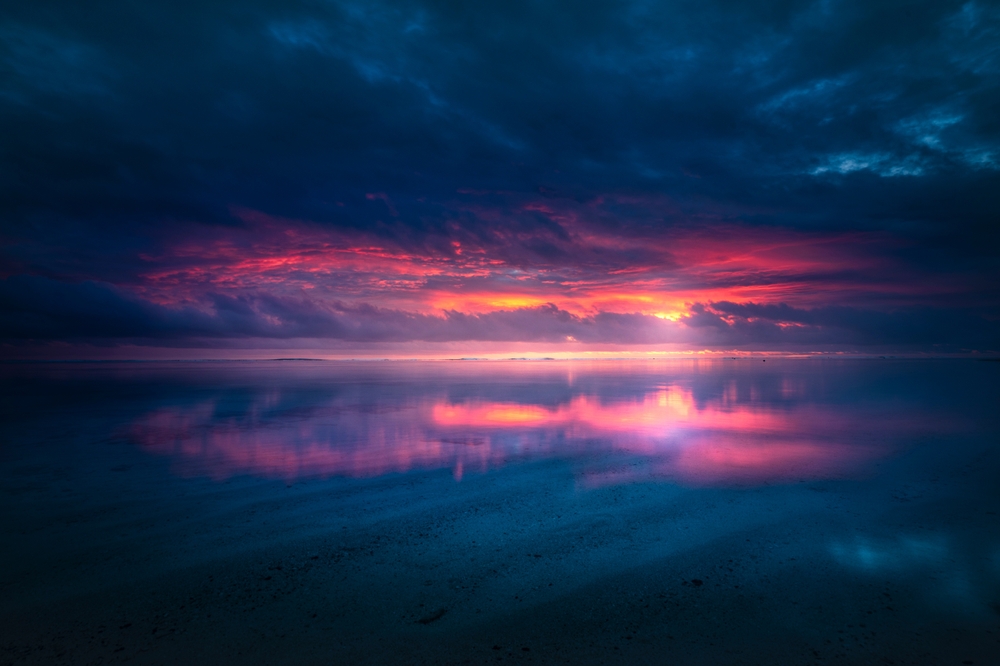 sunset reflects on the calm, shallow waters of a lagoon