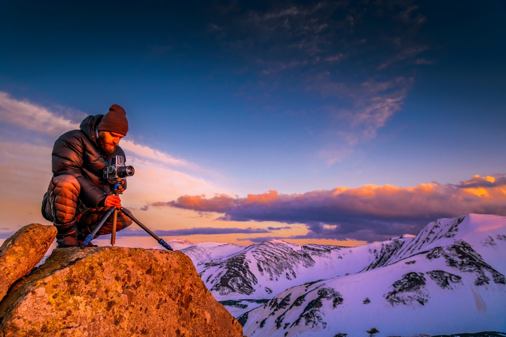 photographer with camera and tripod in winter