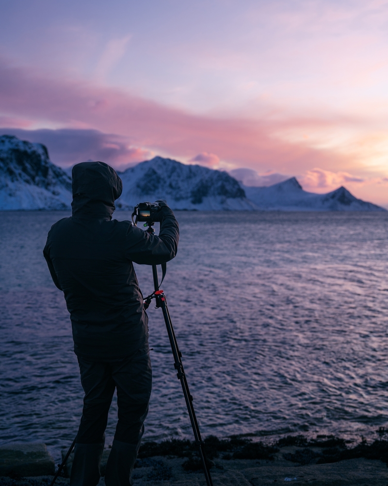 man photographing winter sunset