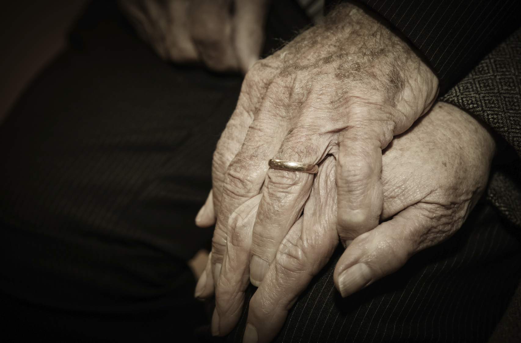 close up of elderly couple holding hands