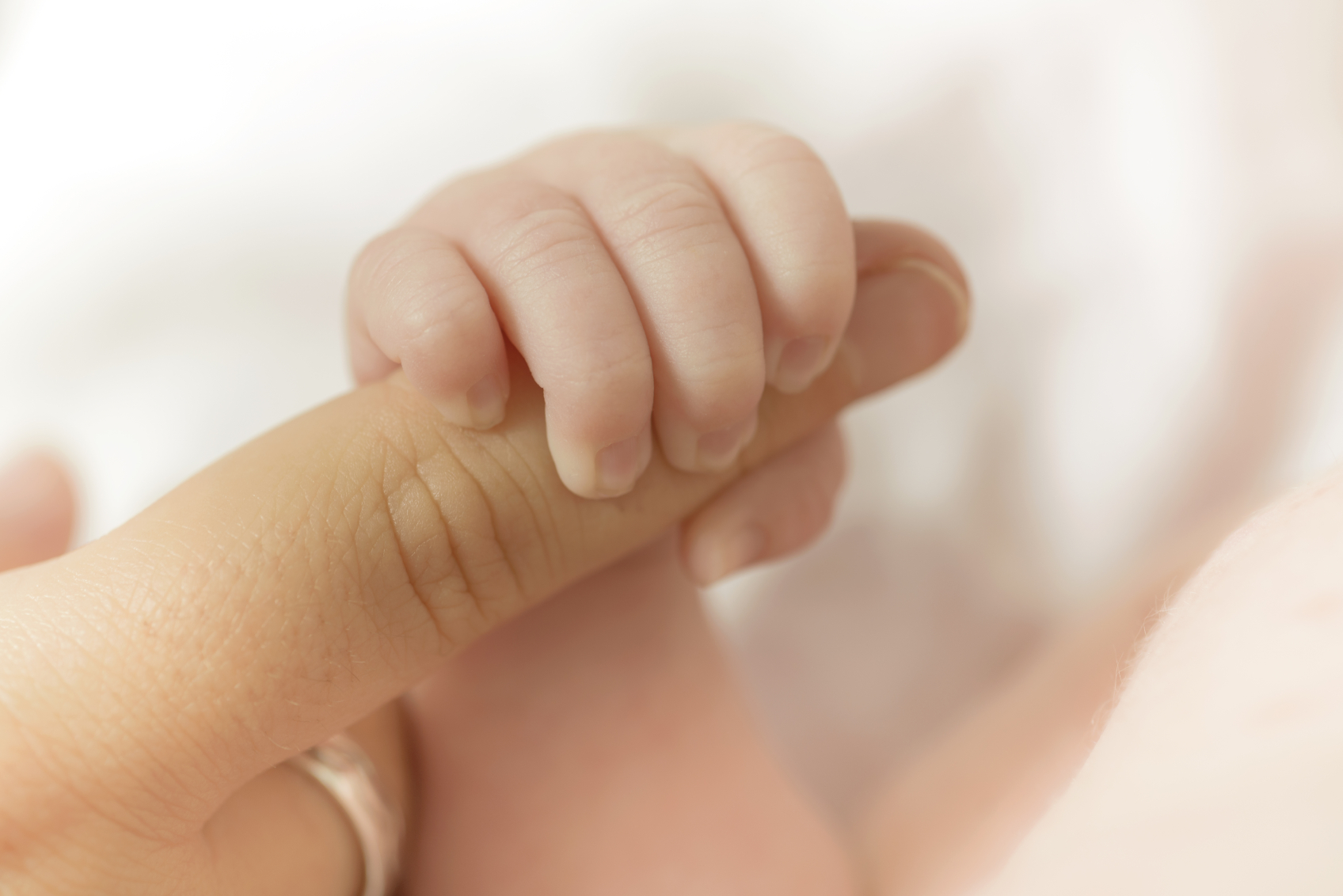 close up of a baby holding a finger