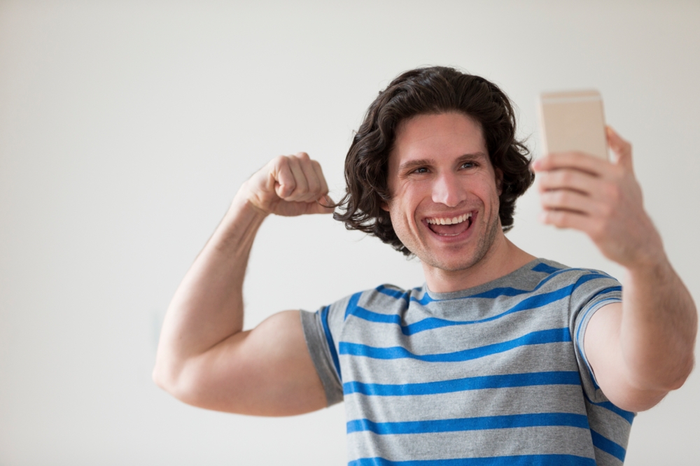 man showing bicep taking a selfie