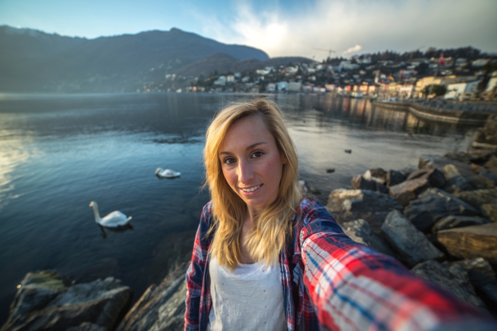 woman taking selfie in front of a lake