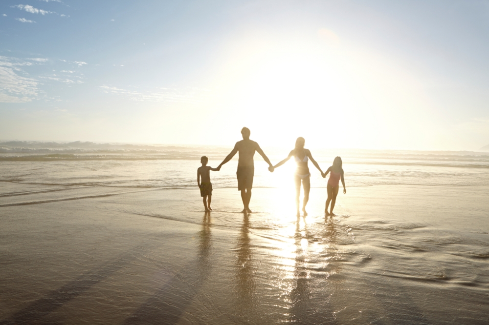 silhouettes of a family on the beach