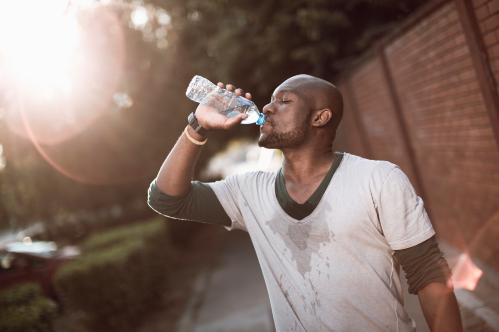 man drinking water while working out
