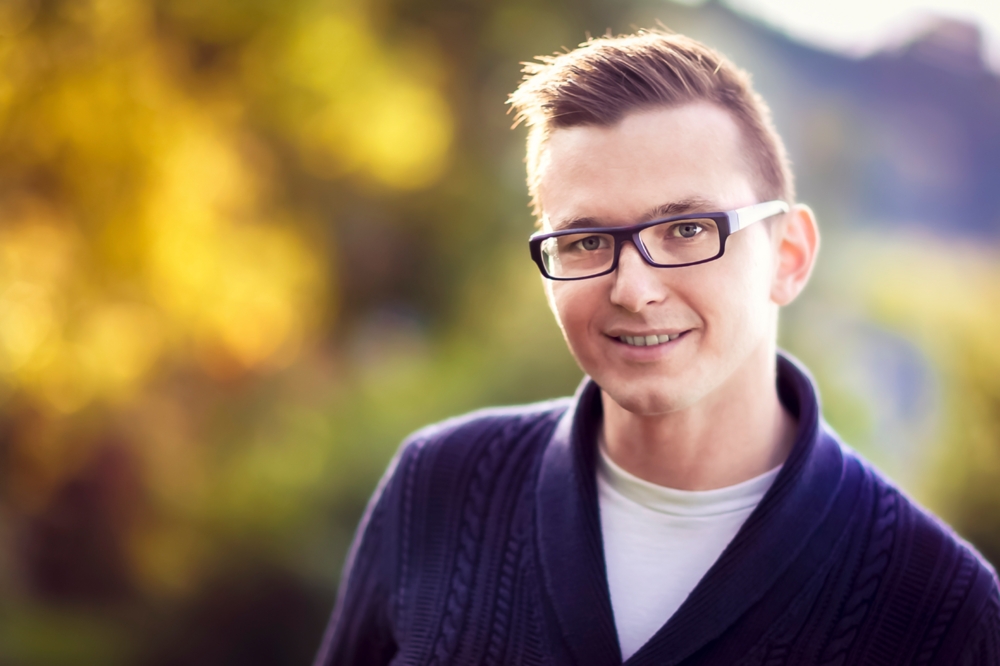 Man with bokeh background of fall trees