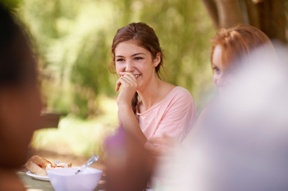 Candid photo of a woman laughing during a meal