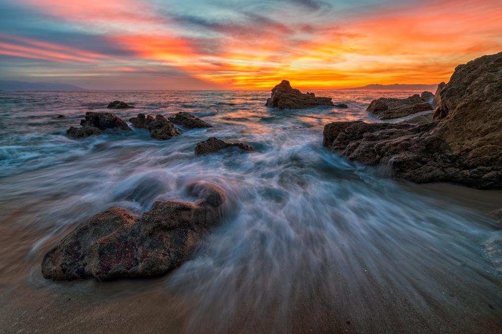 long exposure Ocean Sunset With A Wave Breaking On Shore