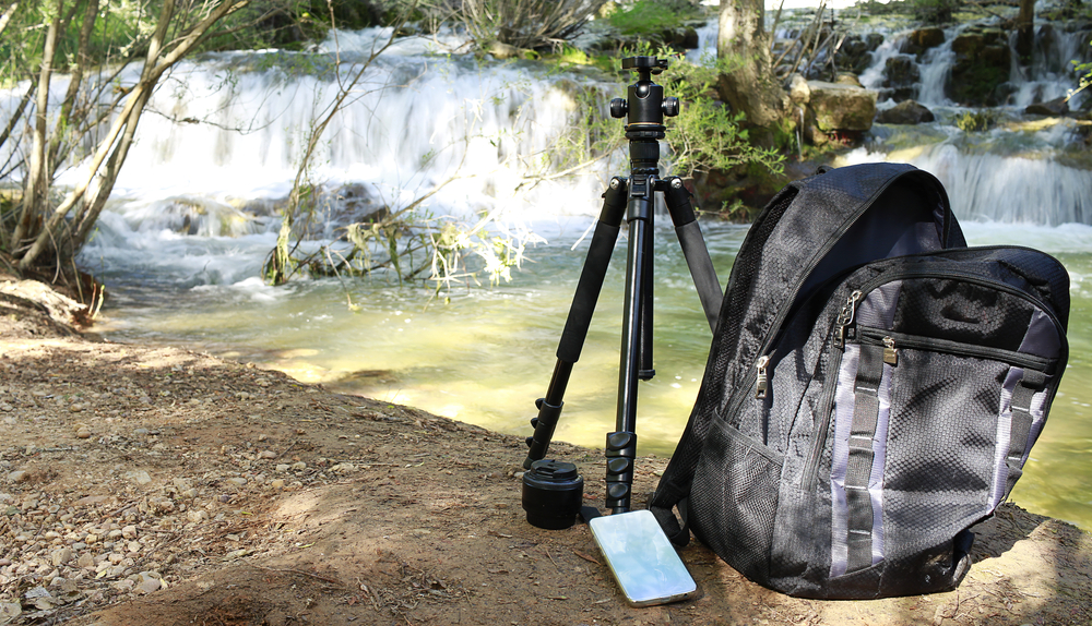 smartphone and tripod by waterfall