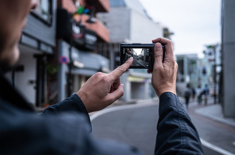 person focusing a Ricoh GR III by touching the back screen