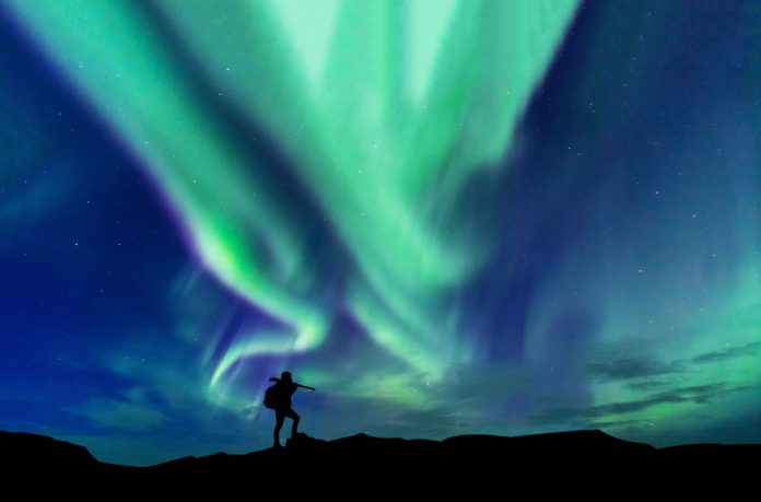 photographer with aurora borealis