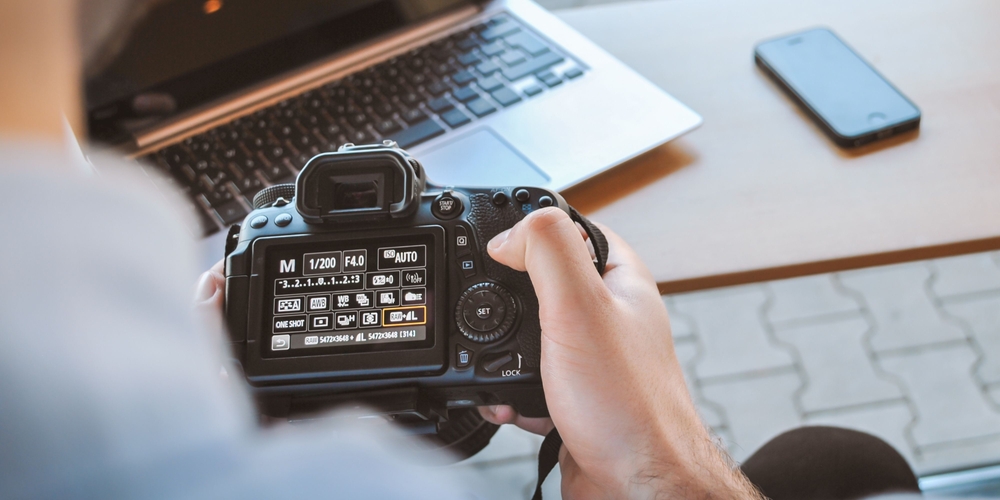 Photographer adjusting DSLR camera settings