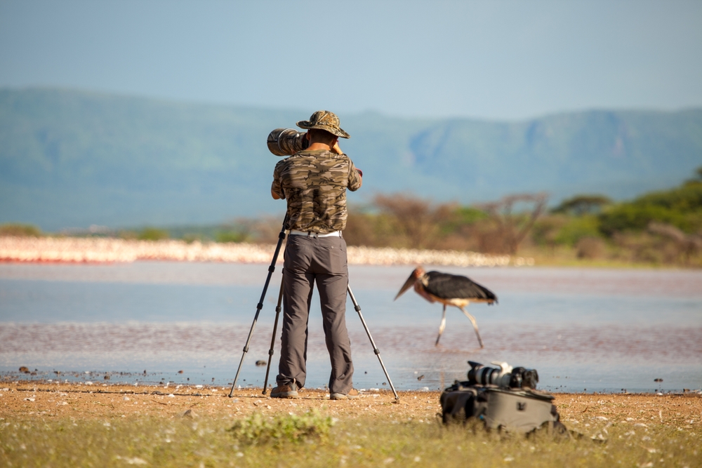 wildlife photographer with camera and tripod