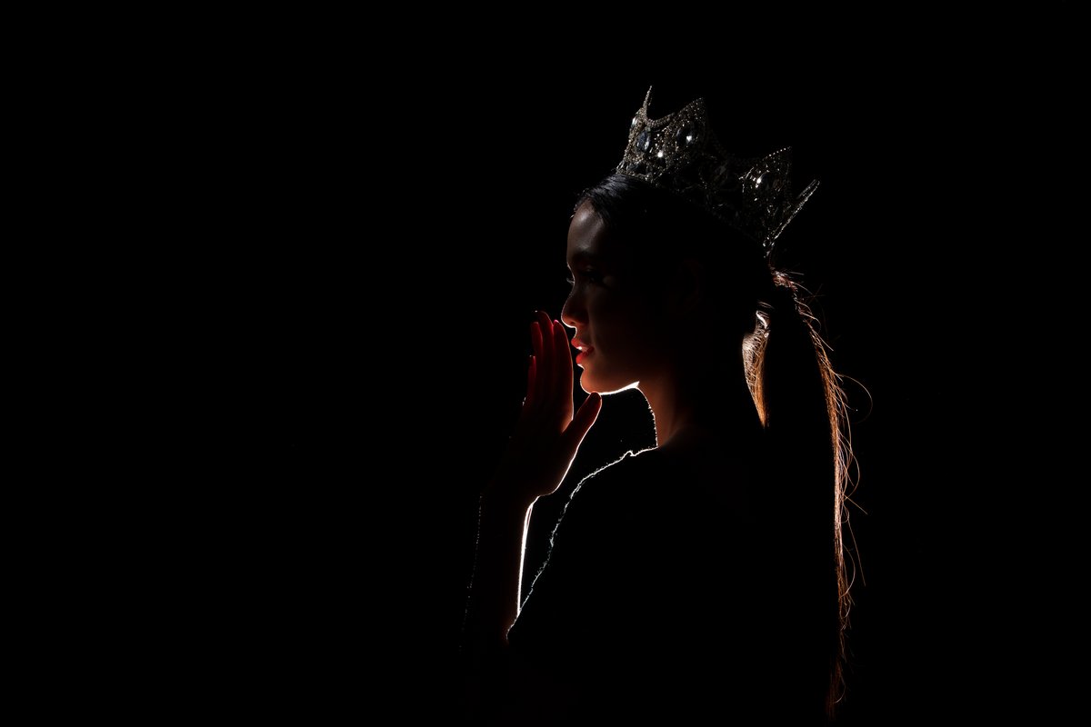 Rim light tracing a glowing outline around a portrait against a dark background