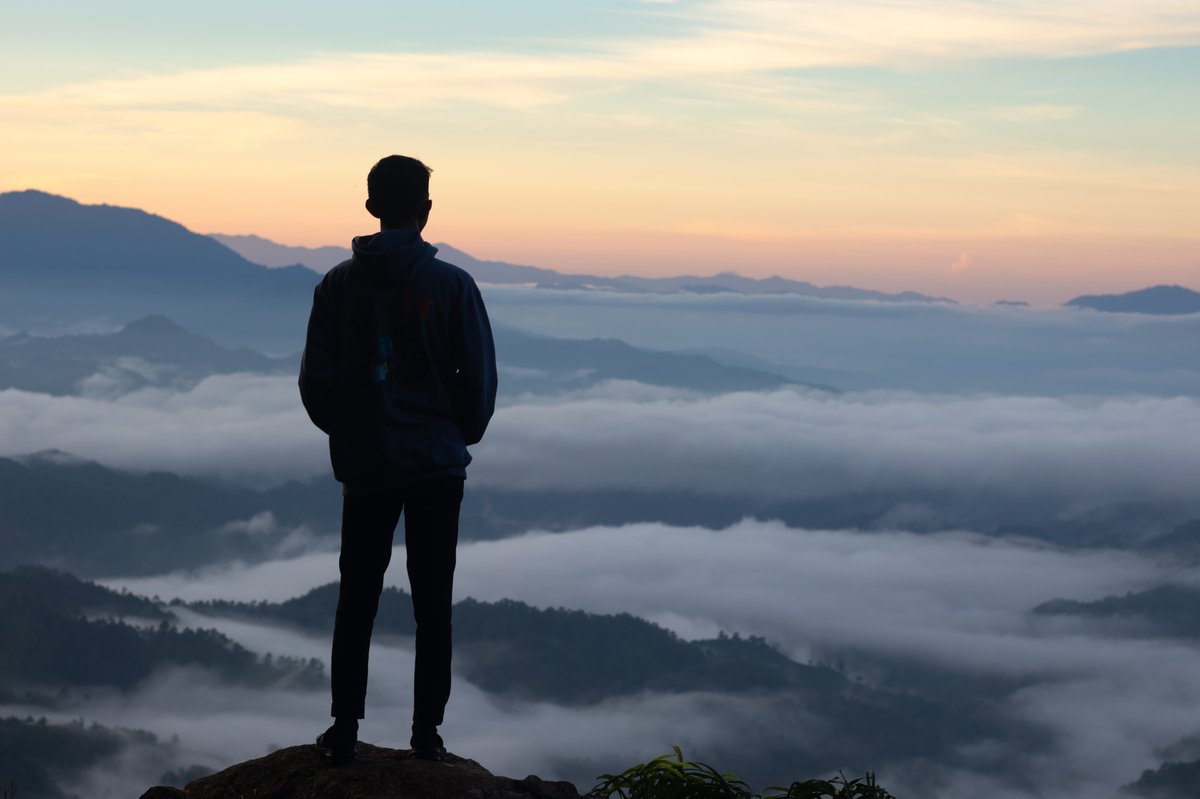 Silhouette of a person against a bright sunrise sky created by backlighting